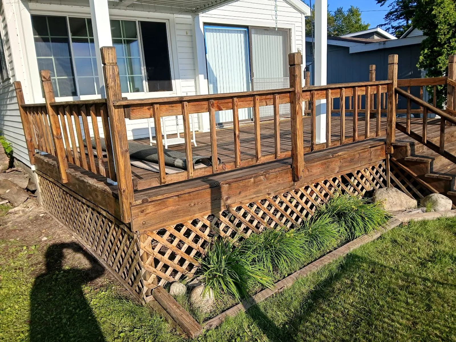 Covered porch and deck area with wood railings and a protected entry